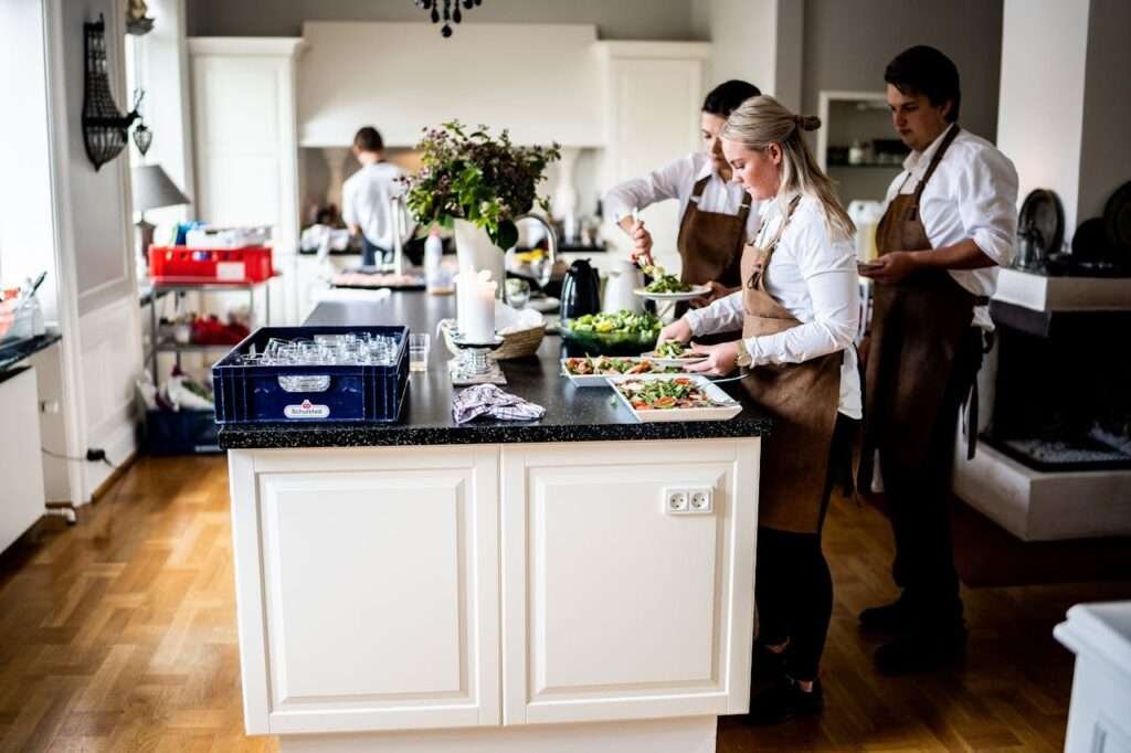 Chefs in a modern kitchen preparing dishes with precision and teamwork, highlighting culinary expertise and professionalism.