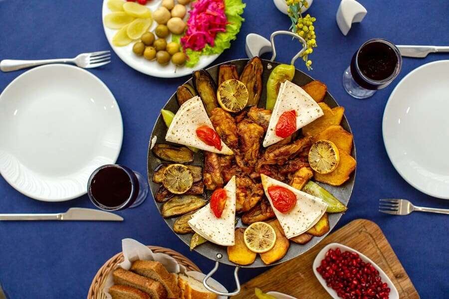 top-view-meat-meal-cooked-along-with-pomegranate-fresh-vegetables-with-bread-slices-blue-table_140725-14299 (1)